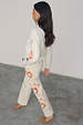 Ecru Enchanted Cut Work Scallop Jeans with colourful sun embroidery and a wide leg, styled with a matching cream cardigan.