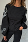 Black Enchanted Lillie Top with white embroidered cut-out motifs on blouson sleeves and a panelled waist.