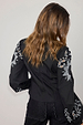 Black Enchanted Lillie Top with white embroidered cut-out motifs on blouson sleeves, back view.