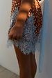 Fawn Mini Maeva Skirt in a brown spot print with an intricate light blue lace border and matching sash.