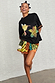 Fiji Elissa Shorts in a cotton-linen blend with a colourful print and orange rick rack trim, styled with a black tee.