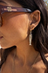 Mixed metal Deloris Sardine Earrings with a silver fish pendant on a gold hoop, shown on a model.