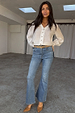 Blue Denim Flare Scallop Jean with a 70s flared silhouette, styled with a white button-down blouse.
