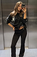 Black cotton flared trousers with ecru embroidered motifs, styled with a matching sweatshirt for a casual co-ord.