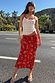 Red Floral Midi Skirt and white pointelle vest with red lace trim, styled for a summer vacation look outdoors.