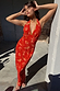 Thumbnail for Red Floral Halter Dress with vintage florals and green trim, worn by a model leaning against a pillar.