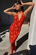 Red Floral Halter Dress with vintage florals and green trim, worn by a model leaning against a pillar.