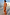 Thumbnail for Burnt orange bias-cut Blurred Floral Sofia Dress with tie-knot shoulders and side slit, an iconic vacation look.