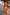 Thumbnail for Iconic Blurred Floral Sofia Dress in burnt orange with tie-knot shoulders, styled for a sunny vacation.