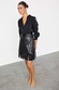 Thumbnail for Black Vegan Leather Mini Fringe Jaspre Skirt with wrap fastening, styled with a black blouse and pointed tan heels.