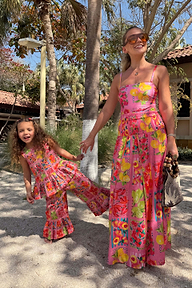 NFD Kids Pink Fruit Wide Leg Set with a cotton peplum top and frill hems on a child posing on a sandy beach vacation.