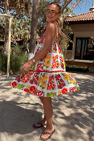 Fruit Stamps Mini Dress featuring a Mediterranean-inspired fruit print and tiered skirt in a sunny outdoor setting.