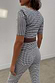Black and white gingham co-ord with skinny leg trousers and a matching top, finished with a brown woven belt.