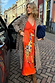 Thumbnail for Orange Giraffe Emma Dress with a crochet top and printed skirt, styled with a leopard coat on a cobbled street.