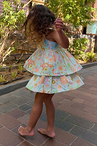 Girl's Starburst Skirt Co-ord Set in blue cotton with a pink sun and star print, worn outdoors.