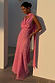 Pink Sophie bias-cut maxi dress with gold fleck and multi-wear scarf on a model leaning against a white pillar.