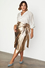 Gold vegan leather Jaspre wrap skirt styled with a white button-down shirt and blue heels.
