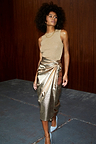 Gold Vegan Leather Jaspre Skirt, a metallic wrap midi styled with a neutral knit top and blue heels.