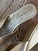 Gold Wedge Mule detail featuring a metallic leather insole with a black sun graphic and brand logo.