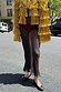 Gold Fringe Jacket with tiered foil tassels, a statement staple styled with a sheer black skirt on a city street.