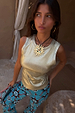 Metallic Gold Ribbed Tank Top paired with blue sun-print trousers and a statement sun necklace.