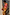 Thumbnail for Green Abstract Sabine Dress in a multicoloured jersey with a cowl halter neck, styled with a beaded bag.