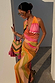 Green Abstract Sabine Dress in a multicoloured jersey with a cowl halter neck, styled with a beaded bag.