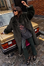 Green Faux Fur Coat in a relaxed fit, leaning against a vintage gold car on a cobblestone London street.