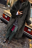 Green Faux Fur Coat with a hot pink lining, leaning against a vintage gold car for a London street style look.