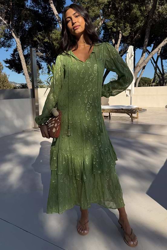 Olive Green Jacquard Harmony Dress with gold animal print, tiered ruffles and tassel neck, styled on a model outdoors.
