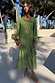 Green Jacquard Harmony Dress in olive green with gold animal print, pleated skirt and tassel neckline on a model.