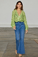 Green Jacquard Miley Shirt with gold animal print and puffed sleeves, tucked into high-waisted blue flare jeans.