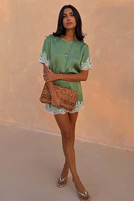 Green Lace Mini Dress with contrast cream lace trims and a shift silhouette, paired with a leopard print clutch.