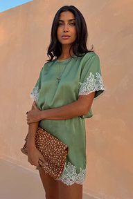 Green Lace Mini Dress featuring contrast cream lace trims and a shift silhouette, paired with a leopard print clutch.