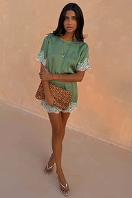 Green Lace Mini Dress with contrast cream lace trims, styled with a leopard print clutch and silver sandals.