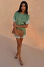 Green Lace Mini Dress with contrast cream lace trims, styled with a leopard print clutch and silver sandals.
