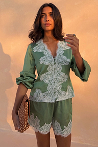 Green Lace Maeva Shorts in satin with white lace trim, styled with a matching top and patterned clutch.