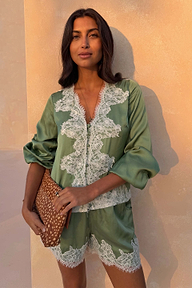 Green Lace Maeva Shorts in satin with white lace trim, styled with a matching top and animal print clutch for vacation.