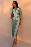 Thumbnail for Green Lace Wrap Midi Skirt with cascading white lace and tie waist, styled with a matching top on a model.