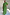 Thumbnail for Green Shirred Nara Dress with a shirred bodice, puff sleeves and pleated skirt on a curve model.