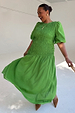 Green Shirred Nara Dress featuring a shirred bodice and short puff sleeves on a smiling model.