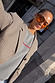 Grey Rest and Recharge Jumper with red lettering, layered under a check blazer for a versatile London look.