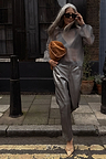 Gunmetal Vegan Leather Trousers paired with a sheer top and tan clutch for a London street style look.