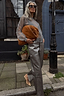 Thumbnail for Gunmetal Vegan Leather Trousers styled with a sheer grey top and tan suede bag on a London street.