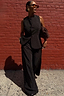 Black Hotfix Marnie Trousers with diamante detail, styled as a co-ord set against a red brick wall.