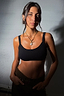 Deloris I Love You Lariat Necklace in gold brass with a chunky chain and spinning pendant on a model.
