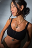 Deloris I Love You Lariat Necklace in chunky brass with a spinning engraved pendant, styled for layering.