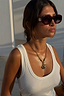 Thumbnail for Deloris I Love You Lariat Necklace in brass with a chunky chain and spinning pendant, worn with a white ribbed vest.