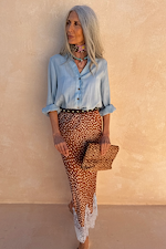 Sky blue Miley Shirt with blouson sleeves and tortoise buttons, tucked into a patterned midi skirt.