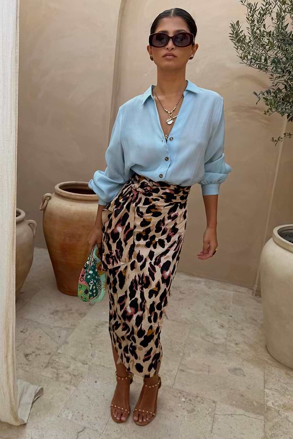 Ice Blue Miley Shirt with blouson sleeves and tortoise buttons paired with a leopard print wrap skirt.